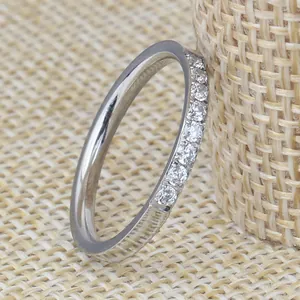 Detailed view of a silver stainless steel ring with a single row of embedded diamonds.