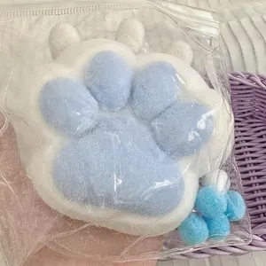 Close-up of a blue and white cat paw squishy toy in plastic packaging for stress relief