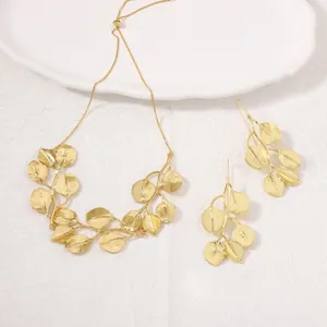 Detailed view of elegant gold leaf pendant necklace and matching drop earrings jewelry set
