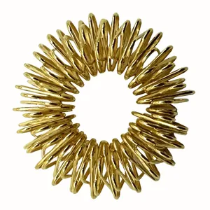 Close-up of golden spiral spring finger massage ring for stress relief and circulation