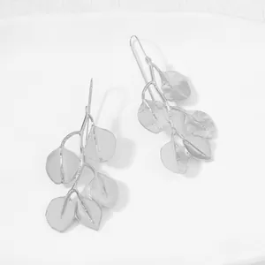 Detailed view of silver zinc alloy leaf branch hook earrings on white background