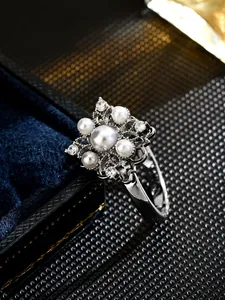 Detail of vintage rotating floral ring with exquisite pearls and silver finish.
