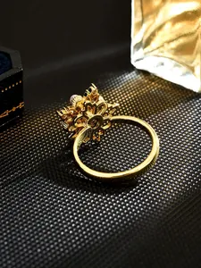 Detailed macro shot of a golden rotating flower ring featuring an elegant white pearl center
