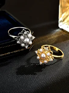 Detail shot of elegant rotating rings with pearl flower design in gold and silver