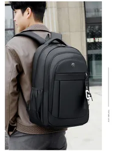 Back view of a man wearing a large capacity black Oxford cloth backpack outdoors