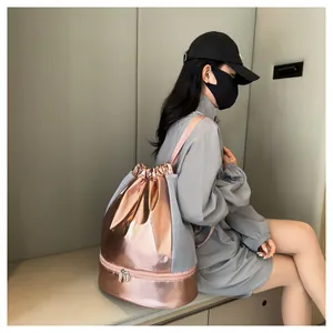 Model wearing the metallic rose gold gym bag featuring a bottom shoe compartment detail