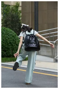 Detailed back view of a woman carrying a black dry-wet gym bag with shoe compartment