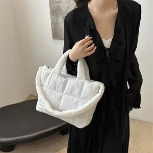Primer plano de un bolso acolchado blanco llevado por una modelo con vestido negro
