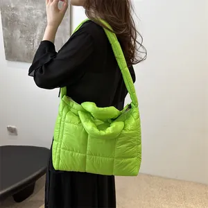 Modelo luciendo un bolso de hombro acolchado verde lima en un entorno moderno