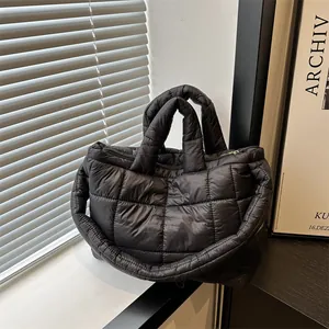 Vista detallada de un bolso acolchado negro en un entorno interior minimalista
