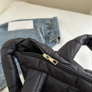 Primer plano de la cremallera dorada en un bolso de hombro acolchado negro ligero