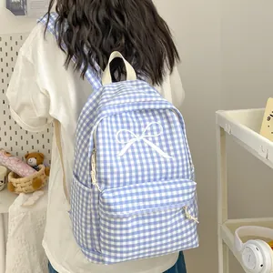 Blauw-wit geruite rugzak met een schattig wit strikje, gedragen door een student.
