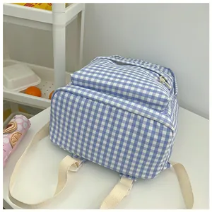 Detailweergave van blauw-witte geruite schoolrugzak met verstelbare schouderbanden.