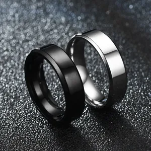 Détail macro de bagues en acier inoxydable biseautées noir et argent fini poli.