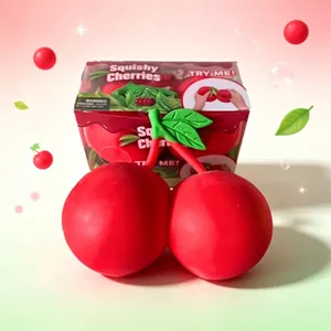 Jumbo red cherry squishy toy with decorative packaging box in a soft pink background