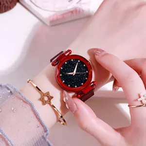 Close-up of a women's red starry sky dial quartz watch on wrist with bracelet