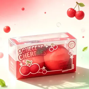 Detailed view of two giant red cherry squeeze toys inside a clear plastic gift box