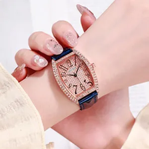 Close-up of a tonneau-shaped quartz watch with rhinestone bezel and blue leather strap