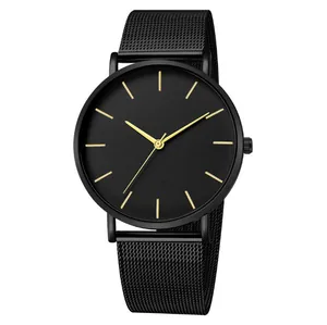 Detail view of a minimalist black mesh strap quartz watch with golden indices.