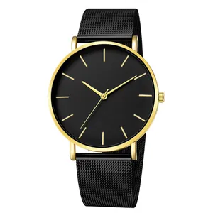 Detail view of a minimalist quartz watch with a black dial and gold-finished metal case