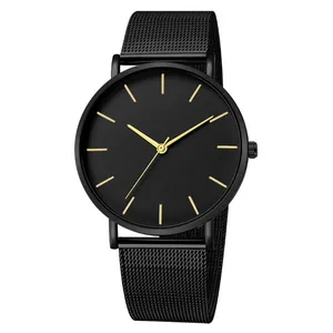 Detail of minimalist black quartz watch with stainless steel mesh strap and gold indices