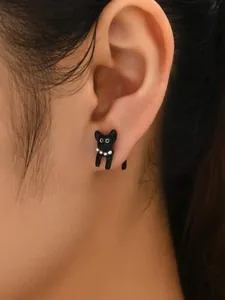 Detailopname van een schattige zwarte kattenoorsteker met een stijlvolle parelketting.