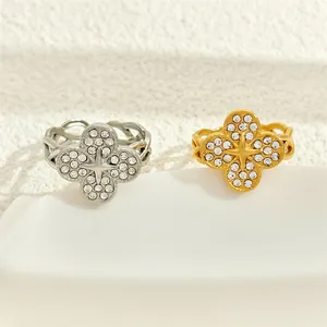Detailed macro view of gold and silver four-leaf clover rings with pavé zircon stones