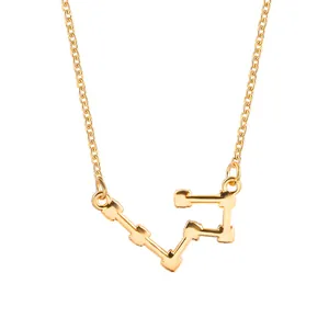 Close-up detail of the elegant gold-tone constellation pendant on a thin link chain