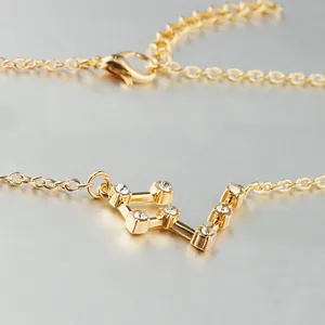 Detailed macro view of a gold-plated Libra constellation pendant necklace with zircon stones