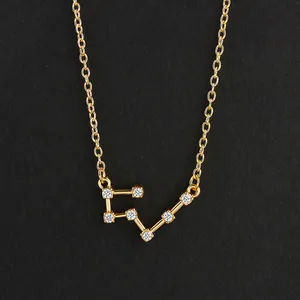 Macro detail shot of a gold constellation pendant necklace set with clear zircon stones.