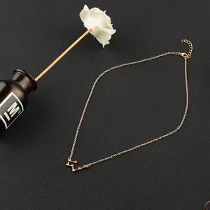 Detailed view of gold constellation necklace with zircon stones on black background