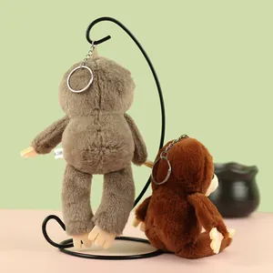 Close-up of two cute plush sloth keychains in brown and grey hanging on a stand