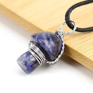Close-up of handmade wire wrapped blue stone mushroom pendant with silver wire detail.