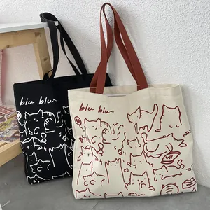 Vista detallada de bolsas de lona con ilustraciones de gatos dibujadas a mano