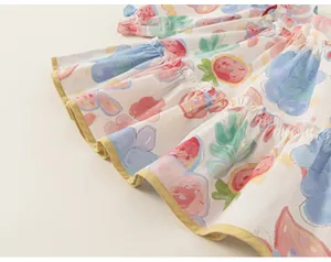 Detailaufnahme des bunten Obst-Graffiti-Musters auf dem gestuften Kleinkind-Kleid