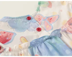 Nahaufnahme eines Baumwollkleides für Mädchen mit Graffiti-Print und roten Knöpfen.