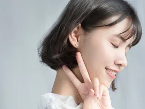 Vue détaillée d'une boucle d'oreille abeille mignonne portée par un mannequin.