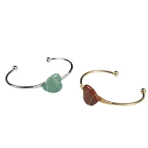 Dettaglio di pietre naturali a cuore cablate a mano su bracciali in oro e argento