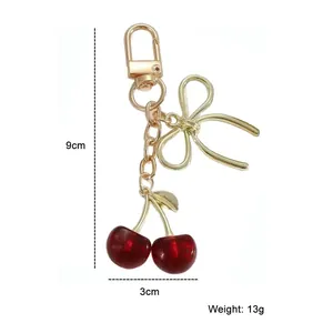 Détail du porte-clés cerise indiquant les dimensions 9x3 cm et le poids 13g