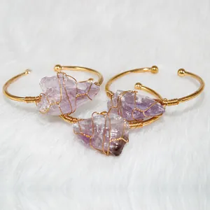 Detailed close-up view of three handmade gold wire wrapped amethyst raw stone bracelets