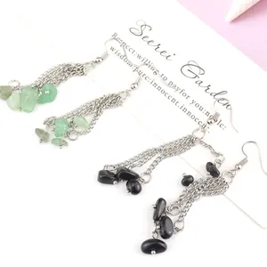 Macro detail of handmade natural stone chip tassel earrings with multi-layer silver chains