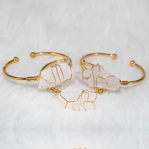 Detailed shot of three gold-plated wire-wrapped raw rose quartz bracelets