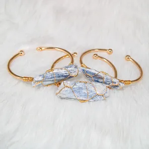 Macro view of blue kyanite crystal stones wire-wrapped on gold-plated cuff bracelets