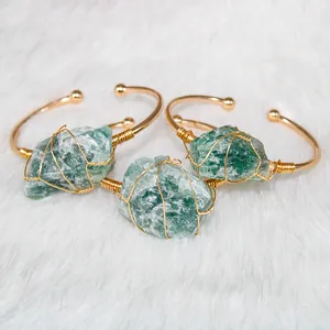 Detailed view of hand-wrapped raw green crystal bangles with an adjustable gold-plated band
