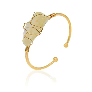 Elegant gold-plated open cuff bracelet with a unique raw yellow crystal focal point.