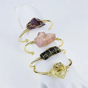 Group of wire-wrapped gold-plated bangles featuring assorted natural raw crystal stones