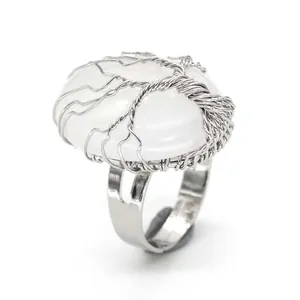 Detailed macro view of silver-plated wire-wrapped Tree of Life ring with oval white crystal