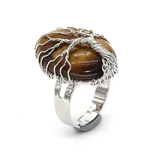 Detail view of a silver wire-wrapped tree of life ring with an oval tiger eye stone.