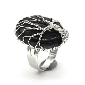 Detailed close-up of a handmade wire-wrapped tree of life ring featuring an oval black stone