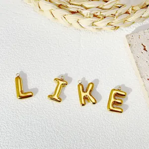 Detail of gold-plated balloon style alphabet pendants L-I-K-E on stone
